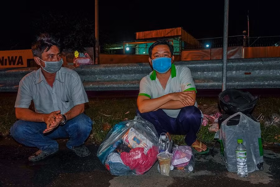 Ông Kiên (bên trái) và anh Tuấn trên hành trình về quê. Ảnh: Duy Tân