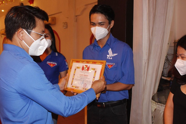 Anh Trần Đoàn Hiệp, Bí thư Quận đoàn, tặng thư khen cho đoàn viên, tình nguyện viên tích cực tham gia hỗ trợ phòng, chống dịch Covid-19. Ảnh: Lê Nam