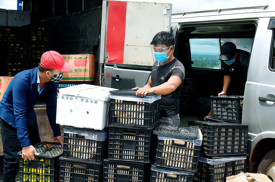  Người dân vận chuyển nông sản lên xe “luồng xanh” để đưa đi tiêu thụ. Ảnh: Đức Thụy