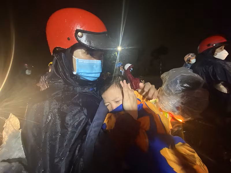 Bé Võ Anh Quân cùng cha mẹ hồi hương về Nghệ An dưới cơn mưa tầm tã.