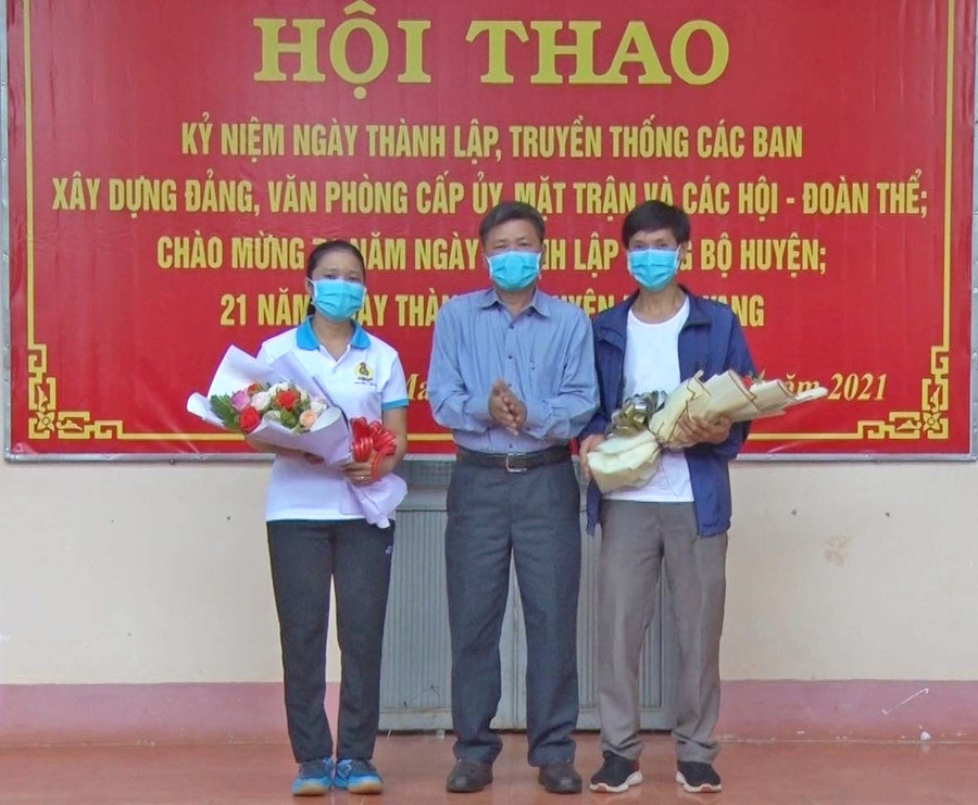 Ông Nguyễn Văn Tha-Phó Bí thư Thường trực Huyện ủy tặng hoa cho đại diện công đoàn 2 khối. Ảnh: Minh Hiển