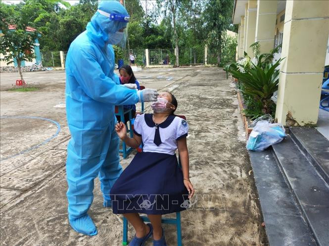 Lấy mẫu xét nghiệm COVID-19 cho học sinh, giáo viên tại Trường Tiểu học Thạnh An. Ảnh: TTXVN phát Lấy mẫu xét nghiệm COVID-19 cho học sinh, giáo viên tại Trường Tiểu học Thạnh An. Ảnh: TTXVN phát