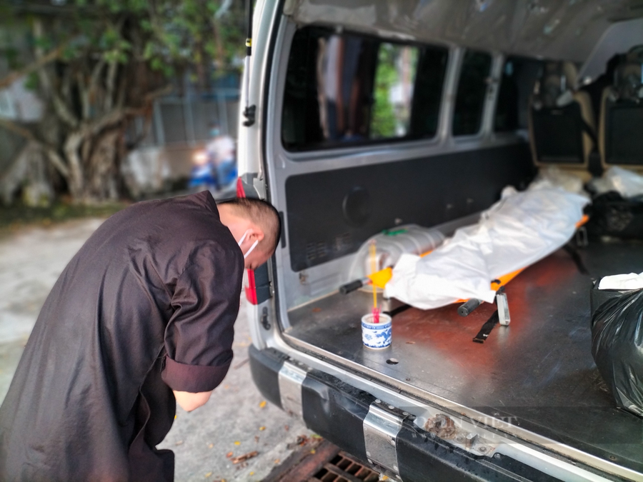 Sau khi tiếp nhận nạn nhân mất vì Covid-19, các tình nguyện viên tiến hành khâm liệm tại chỗ rồi mang ra xe đưa đi mai táng. Ảnh: Chinh Hoàng