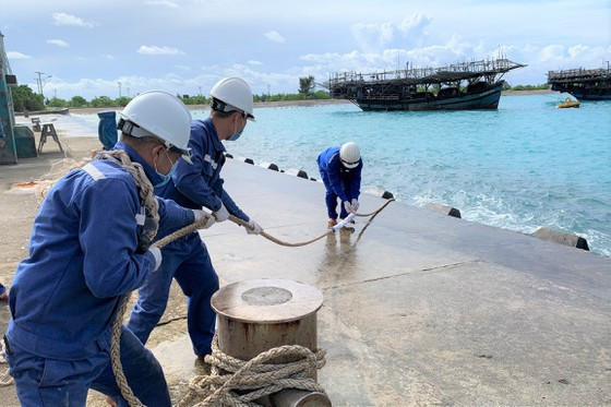 Nhân viên Trung tâm dịch vụ hậu cần - kỹ thuật đảo Sinh Tồn giúp ngư dân gia cố dây buộc Nhân viên Trung tâm dịch vụ hậu cần - kỹ thuật đảo Sinh Tồn giúp ngư dân gia cố dây buộc