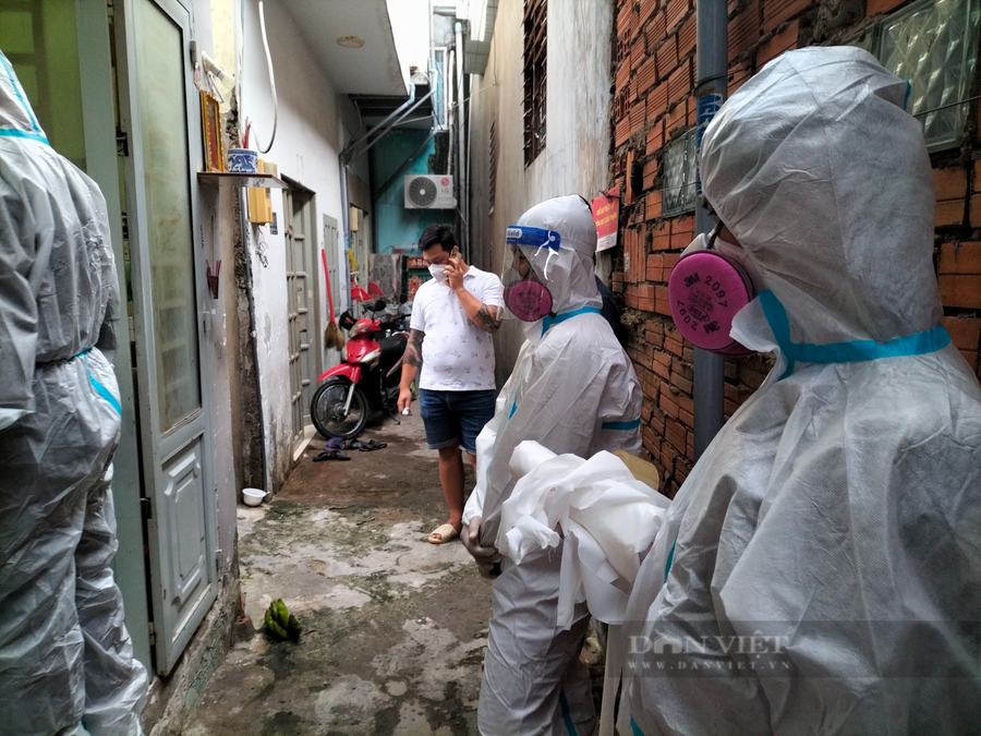 Anh Trương Văn Thịnh (tay nghe điện thoại), để chuẩn bị mang bệnh nhân ra xe, anh liên lạc với phía mai táng trước. Ảnh: Chinh Hoàng