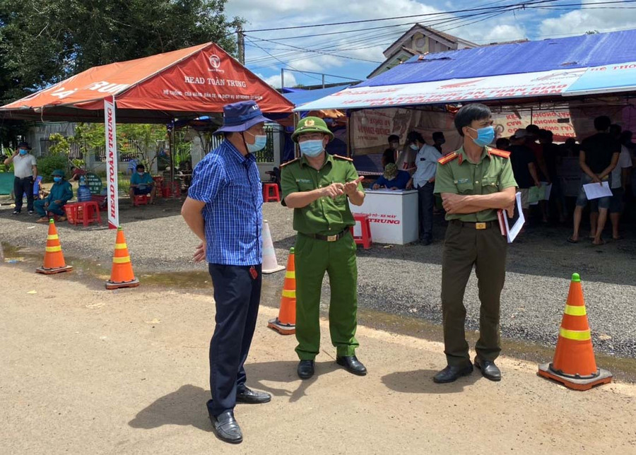 Ông Trần Văn Tư-Giám đốc Công ty TNHH một thành viên Toàn Trung (bìa trái) trao đổi với các lực lượng tại chốt kiểm soát phòng dịch Covid-19 khu vực cầu 110. Ảnh: Anh Huy