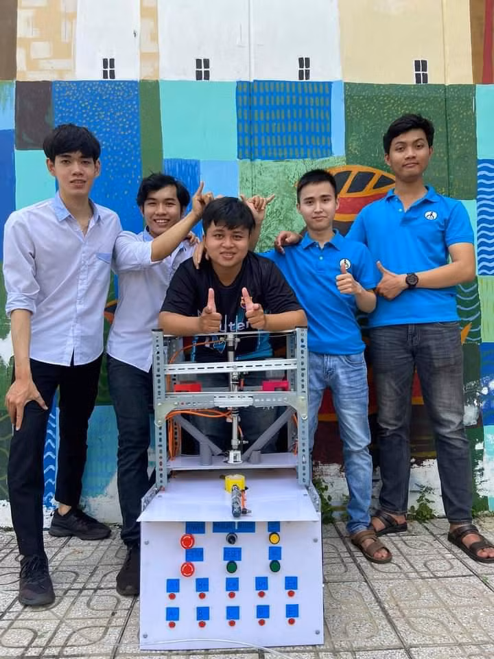 H.Phúc (áo đen) hoàn thành mô hình máy ép cho môn học tại trường. Ảnh: NVCC