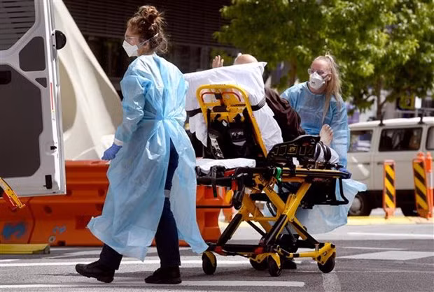 Chuyển bệnh nhân nhiễm COVID-19 tới bệnh viện ở Melbourne, Australia. (Ảnh: AFP/TTXVN)