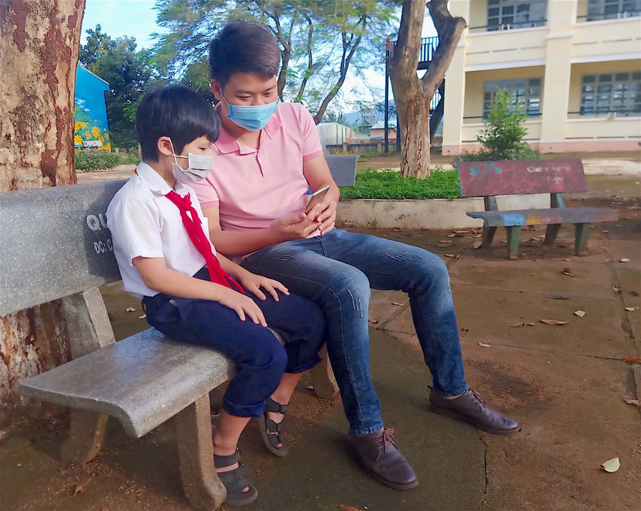 Thầy Trần Văn Nam-giáo viên Tổng phụ trách Đội, Trường Tiểu học và THCS Lê Văn Tám (xã Trà Đa, TP. Pleiku) hướng dẫn học sinh cách sử dụng điện thoại để học tập. Ảnh: Mộc Trà