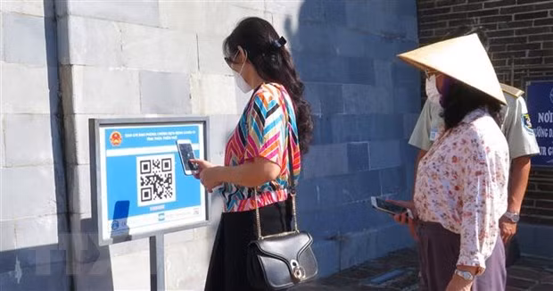 Du khách quét mã QR Code trước khi vào tham quan các điểm di tích tại Huế. Ảnh: Tường Vi/TTXVN
