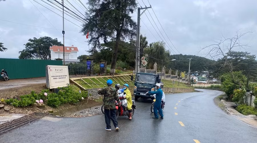 Lực lượng dân quân hướng dẫn xe cộ không đi vào làng hoa Vạn Thành nơi mới phát hiện ổ dịch Covid-19. Ảnh: Lâm Viên