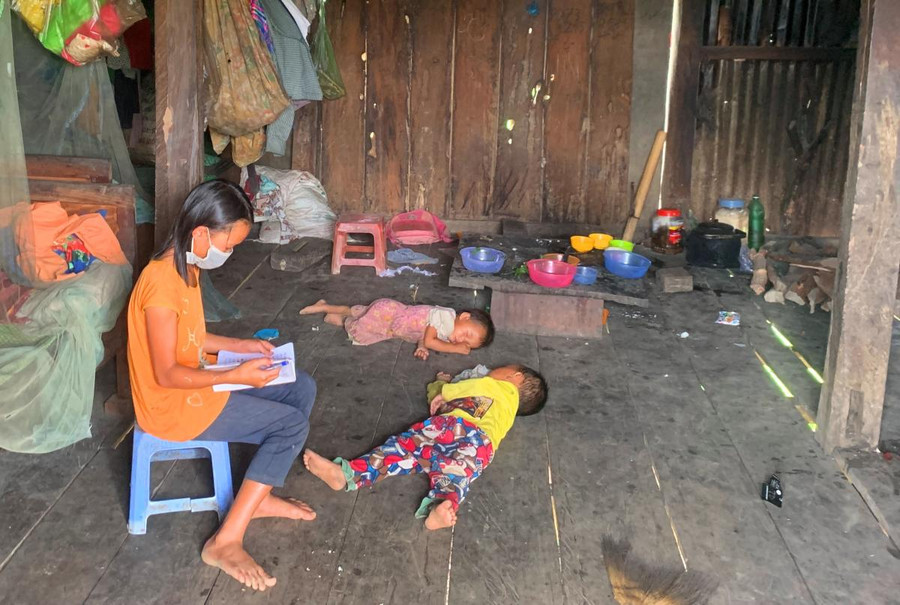 Em Ma Thị Ngọc (làng Mông, xã Ea R'bin, học sinh lớp 4, Trường Tiểu học Ngô Gia Tự) tranh thủ lúc trời còn sáng, thầy chưa đến giao bài vừa trông em vừa học bài.