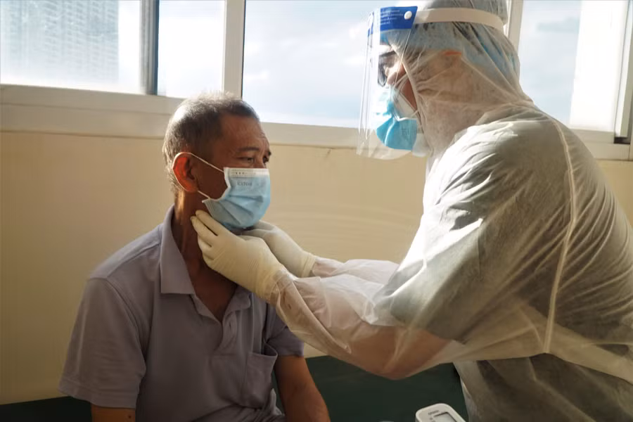 Bác sĩ thăm khám một bệnh nhân tại BVDC điều trị Covid-19 Thủ Đức số 1