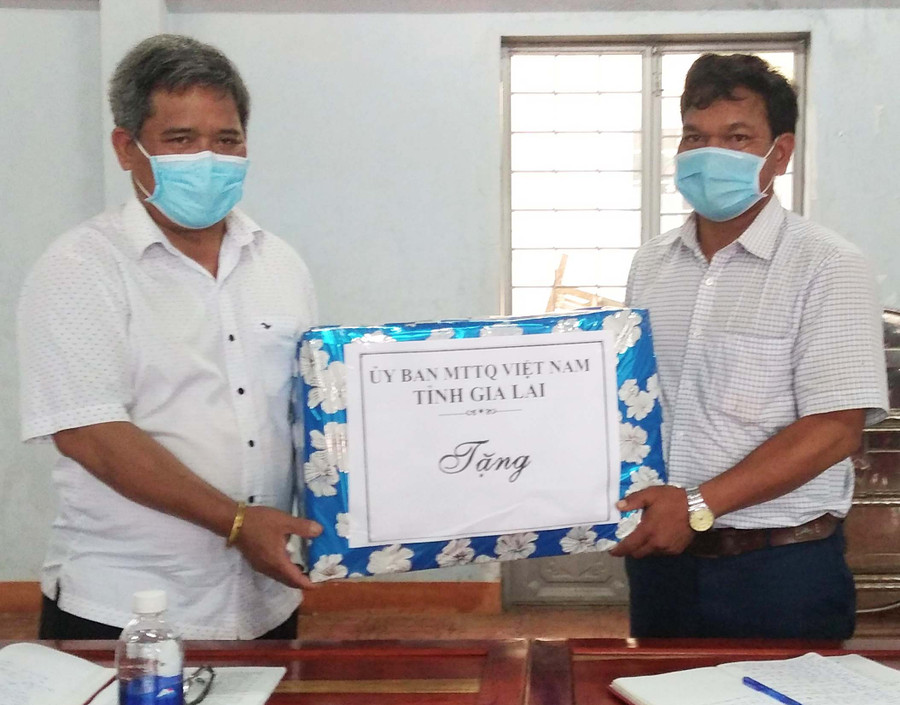 Đồng chí Hồ Văn Điềm tặng quà cho Chi bộ làng Pyầu. Ảnh: Lê Đại