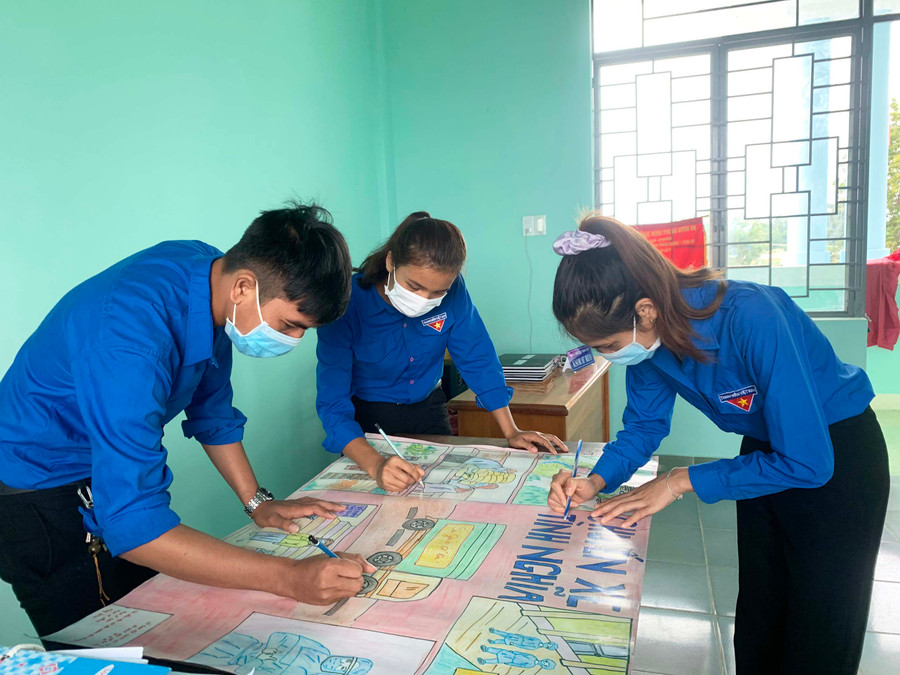 Thông qua bức tranh dự thi, nhóm tác giả Ksor H’Reo, Ksor H’Nhim và Nay Drim (lần lượt từ phải qua, Đoàn xã Ia Sao) kêu gọi mọi người cùng chung tay phòng-chống dịch Covid-19. Ảnh: Nguyên Hương