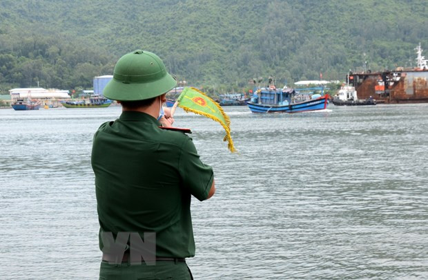 Chiến sỹ tại Trạm kiểm soát Biên phòng Mân Quang (quận Sơn Trà, thành phố Đà Nẵng) ra hiệu lệnh để tàu thuyền vào trạm khai báo. (Ảnh: Quốc Dũng/TTXVN)
