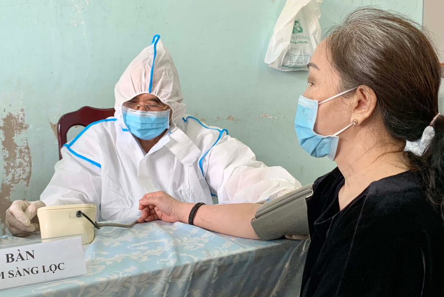 Ông Lưu Sỹ (tổ 1, phường Hội Thương) tham gia khám sàng lọc cho người dân trước khi tiêm chủng. Ảnh: Như Ý