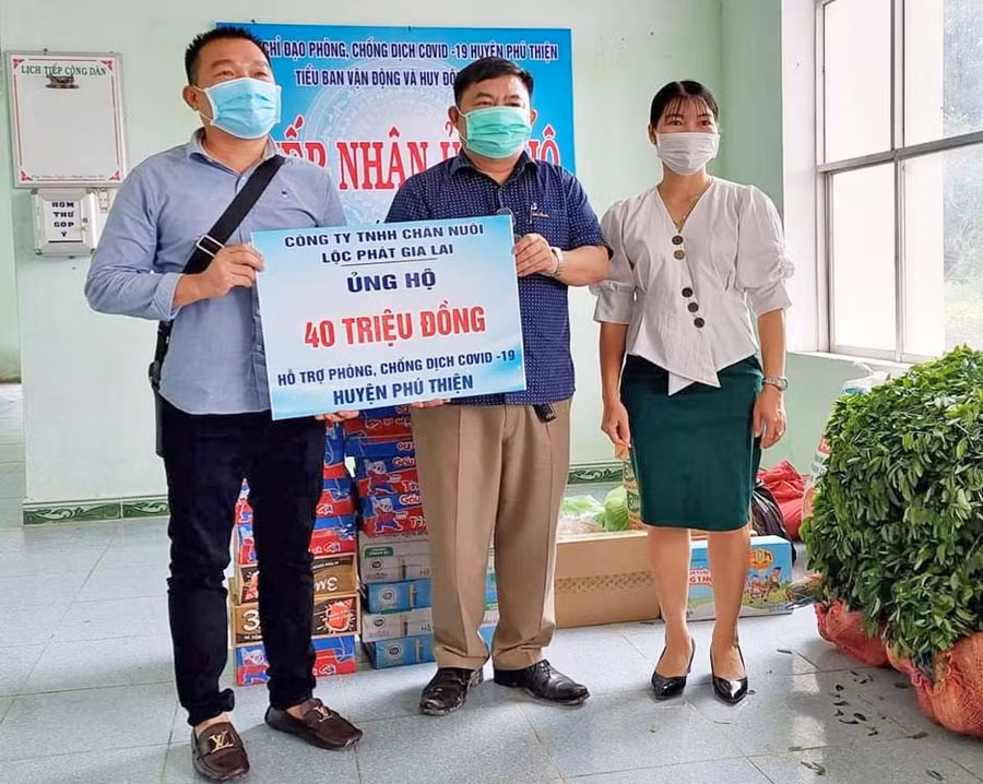 Đại diện Công ty TNHH Chăn Nuôi Lộc Phát Gia Lai (bên trái) trao 40 triệu đồng ủng hộ cho công tác phòng-chống dịch Covid-19 trên địa bàn huyện Phú Thiện. Ảnh: Ngọc Anh