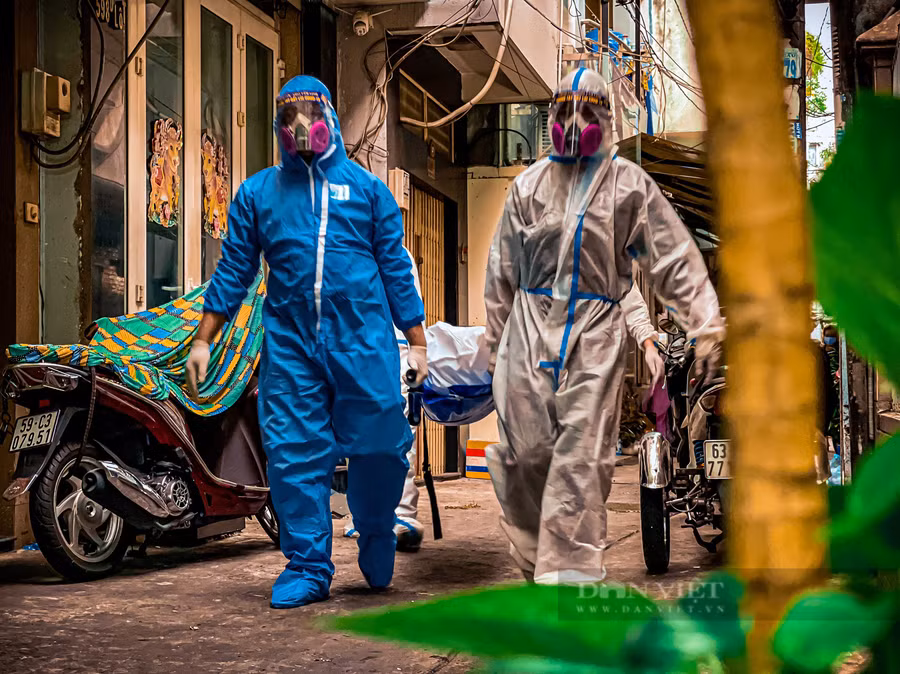 Đưa nạn nhân mất vì Covid-19, 4 người ai nấy đều mặc bảo hộ kín mít. Ảnh: Chinh Hoàng