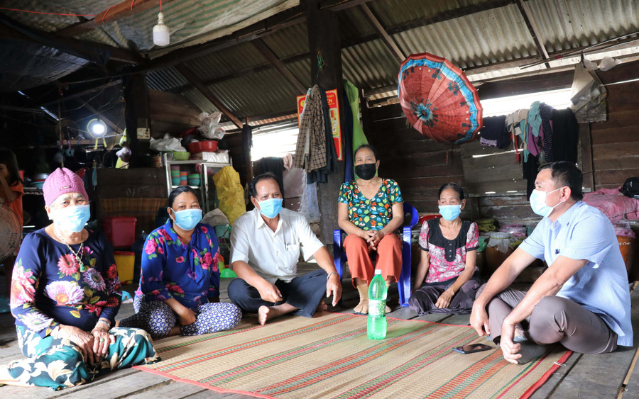 Bà Ksor H'Điu (bìa trái) trò chuyện cùng lãnh đạo UBND xã, Bí thư Chi bộ thôn và bà con thôn Bôn Tông Sê về chuyện bỏ tục chôn chung. Ảnh: Phương Linh