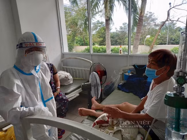 Những F0 khỏi bệnh có nhiều kinh nghiệm chữa và điều trị F0 sẽ hỗ trợ rất tốt cho các y bác sĩ. Một F0 tình nguyện chăm sóc bệnh nhân F0 tại Bệnh viện dã chiến số 4. Ảnh: B.D