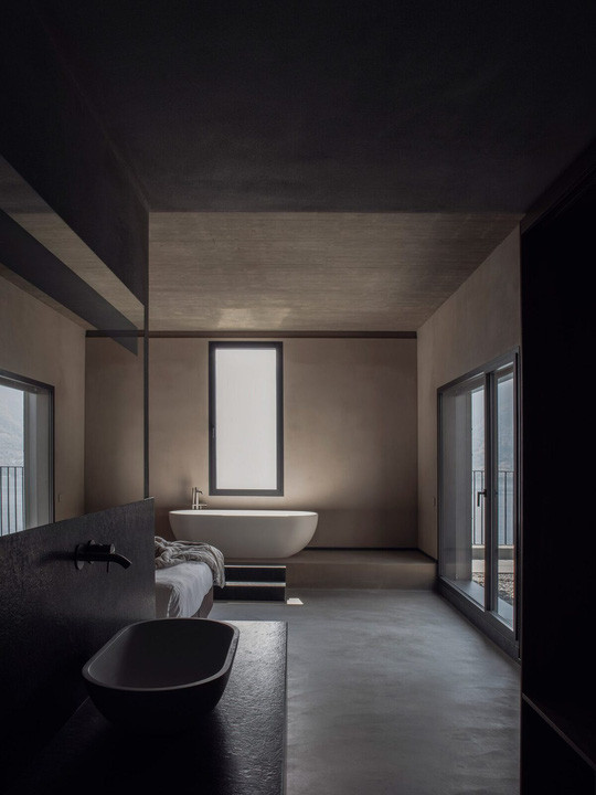 Với ngôi nhà ở Sala Comacina (Italy), văn phòng kiến trúc sư Lorenzo Guzzini chọn giải pháp phòng tắm mở, thông với phòng ngủ chính. Toàn bộ không gian được thiết kế với tông màu tối của đá serpentine, bê tông và thạch cao nhằm đem tới sự đối lập với thiên nhiên bên ngoài.