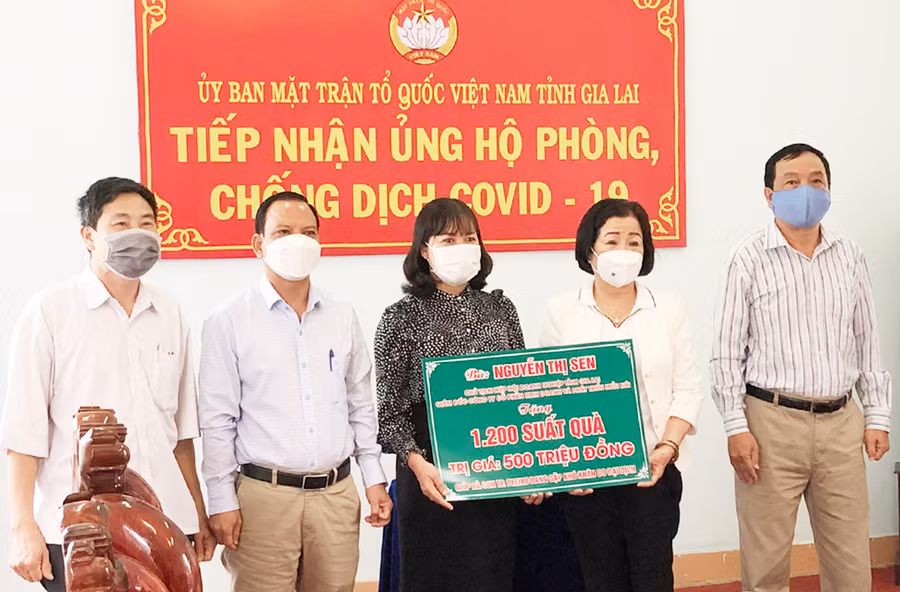  Bà Nguyễn Thị Sen (thứ 2 từ phải sang)-Chủ tịch Hiệp hội Doanh nghiệp tỉnh, Giám đốc Công ty cổ phần kinh doanh và phát triển Miền núi Gia Lai trao tặng 1.200 suất quà cho người dân TP. Pleiku gặp khó khăn. Ảnh: C.T.V