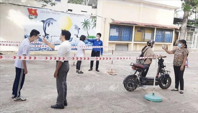 Các trường học trên địa bàn thành phố Quy Nhơn đo thân nhiệt khi học sinh vào trường. Ảnh: Tường Quân/TTXVN Các trường học trên địa bàn thành phố Quy Nhơn đo thân nhiệt khi học sinh vào trường. Ảnh: Tường Quân/TTXVN