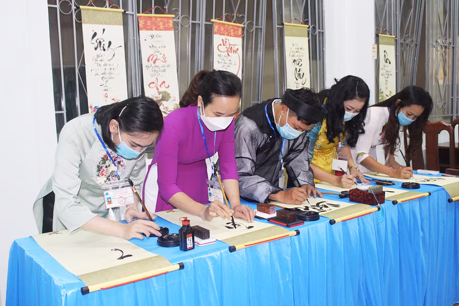 Các thành viên Câu lạc bộ Thư pháp chữ Việt Pleiku khai bút, tặng tranh tại lễ ra mắt. Ảnh: Phan Lài