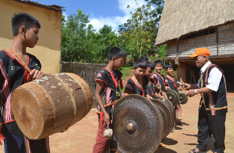 Nghệ nhân A Nian truyền dạy cồng chiêng cho đội cồng chiêng nhí của làng. Ảnh: V.N