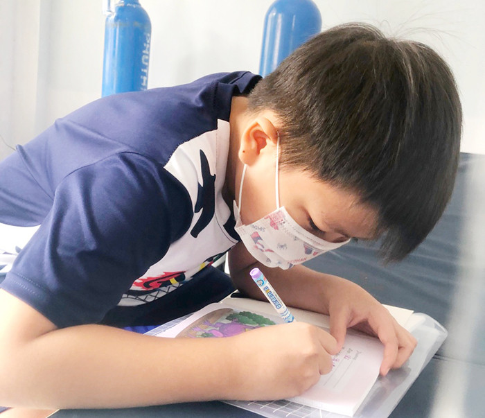 Lấy mặt giường làm bàn học.