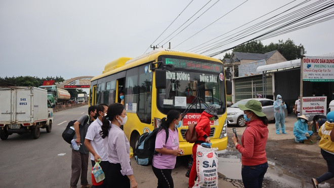 Chiếc xe buýt chở những người đang đi bộ dọc tuyến đường ĐT.741 về quê lên chốt kiểm soát dịch Covid-19 giáp ranh giữa Bình Dương và Bình Phước. Ảnh: Hoàng Giáp