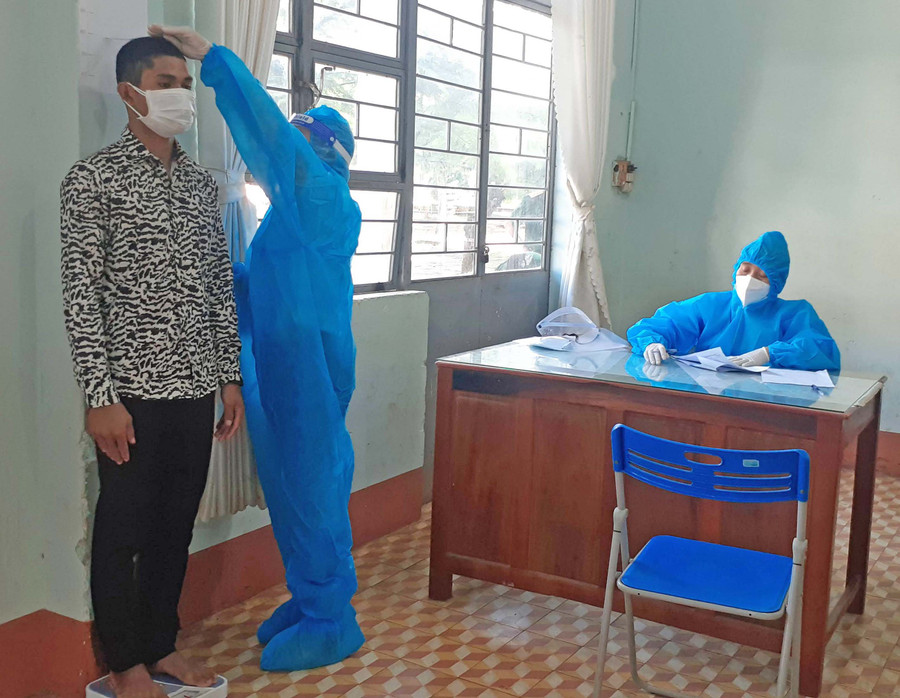 Bác sĩ thực hiện đo chiều cao cho công dân. Ảnh: Hoàng Viên