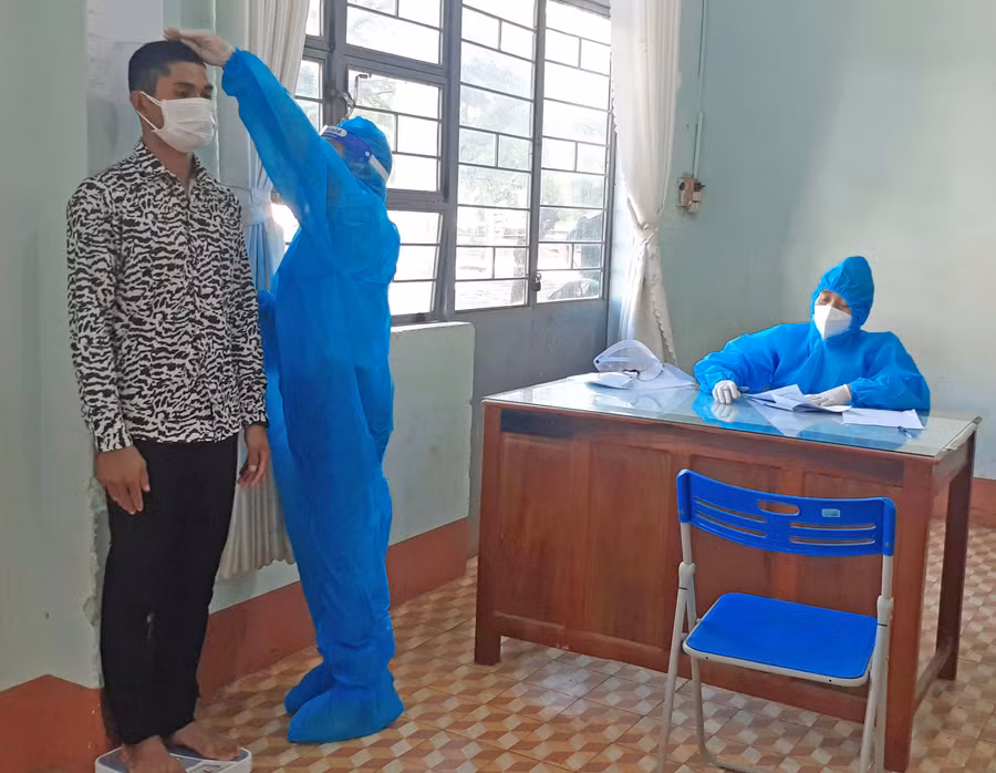 Bác sĩ thực hiện đo chiều cao cho công dân. Ảnh: Hoàng Viên