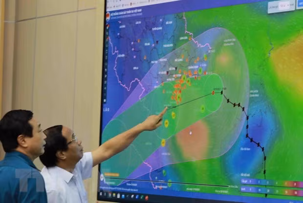  Phó Thủ tướng Lê Văn Thành xem sơ đồ đường đi của bão số 7. (Ảnh: Vũ Sinh/TTXVN)
