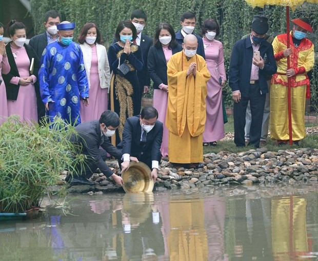 Thả cá chép theo nghi thức truyền thống. Ảnh: Thanh Tùng/TTXVN