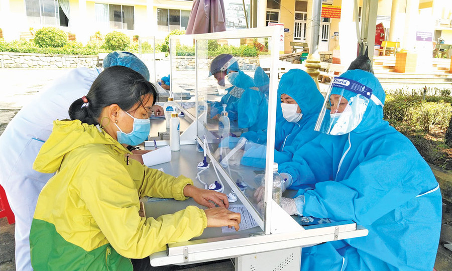 Người dân thực hiện khai báo y tế, đo thân nhiệt trước khi vào khám-chữa bệnh tại Bệnh viện Đa khoa tỉnh. Ảnh: Ngọc Thu