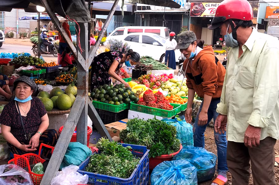 Bà Cù Thị An (bìa trái) bán rau ở chợ. Ảnh: Đinh Yến