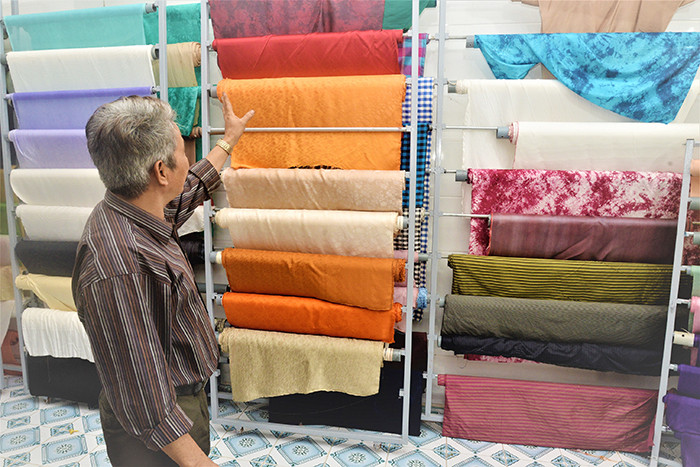 Ông Trần Văn Phương trong kho lụa của mình.