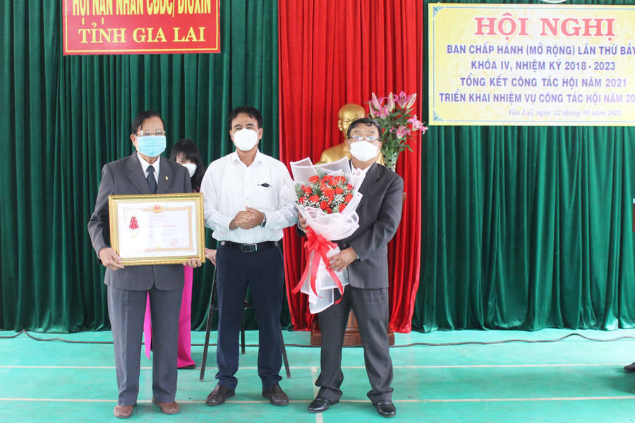 Thừa ủy nhiệm của Chủ tịch nước, đồng chí Rơ Chăm La Ni (ở giữa)-Phó Trưởng ban Dân vận Tỉnh ủy tặng Huân chương Lao động hạng Ba cho Hội Nạn nhân chất độc da cam/Dioxin tỉnh. Ảnh: Phan Lài