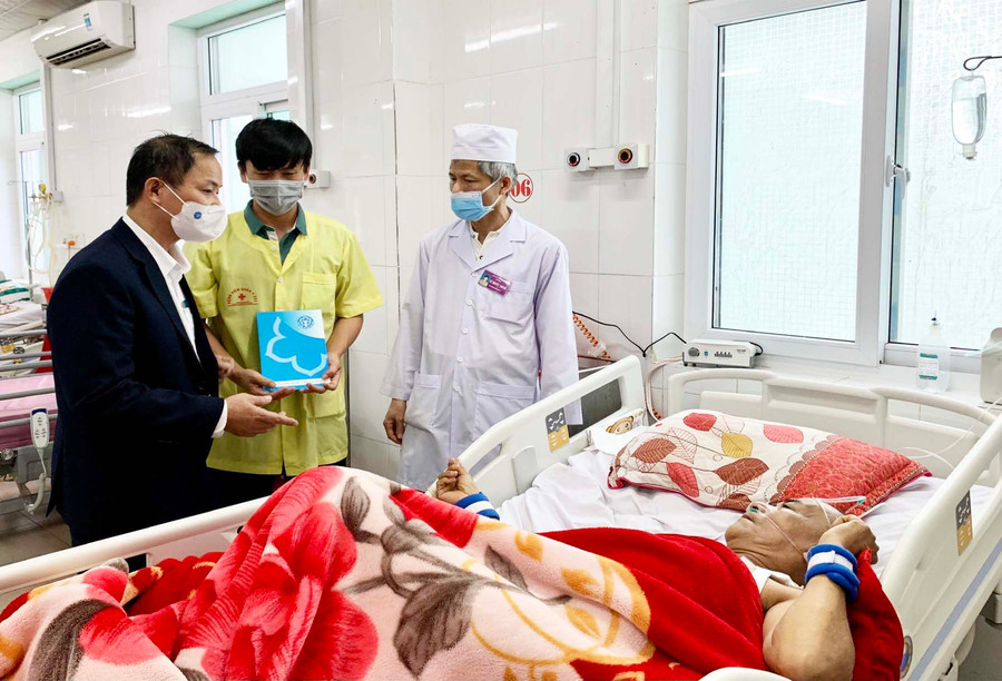 Phó Giám đốc BHXH Gia Lai Lê Quốc Khánh (áo đen) trao quà cho bệnh nhân BHYT tại Bệnh viện 211. Ảnh: Như Nguyện