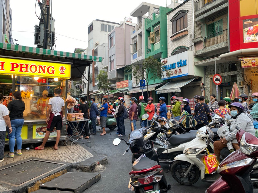 Nhiều người xếp hàng dài chờ mua heo quay, vịt quay trên đường Bùi Hữu Nghĩa, Q.5, TP.HCM trong ngày tháng Chạp. Ảnh: Bảo Vy