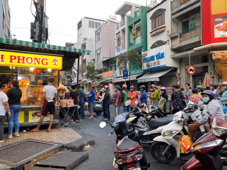 Nhiều người xếp hàng dài chờ mua heo quay, vịt quay trên đường Bùi Hữu Nghĩa, Q.5, TP.HCM trong ngày tháng Chạp. Ảnh: Bảo Vy