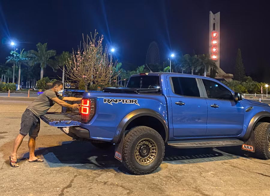 Người dân mua hoa đào ở chợ hoa Tết Đà Nẵng lúc đêm muộn. Ảnh: Huy Đạt