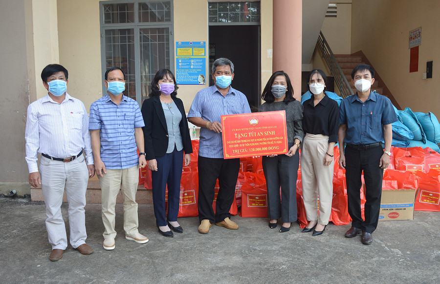 Ông Hồ Văn Điềm (ở giữa)-Ủy viên Ban Thường vụ Tỉnh ủy, Chủ tịch Ủy ban MTTQ Việt Nam tỉnh tặng túi an sinh cho người dân trong khu vực phong tỏa do dịch Covid-19 tại phường Yên Đổ (TP. Pleiku). Ảnh: Anh Huy