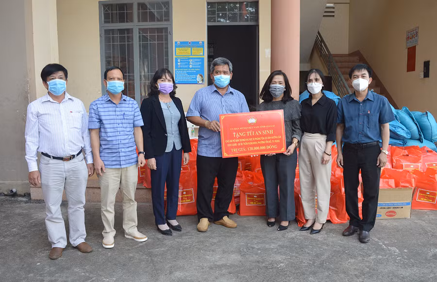 Ông Hồ Văn Điềm (ở giữa)-Ủy viên Ban Thường vụ Tỉnh ủy, Chủ tịch Ủy ban MTTQ Việt Nam tỉnh tặng túi an sinh cho người dân trong khu vực phong tỏa do dịch Covid-19 tại phường Yên Đổ (TP. Pleiku). Ảnh: Anh Huy