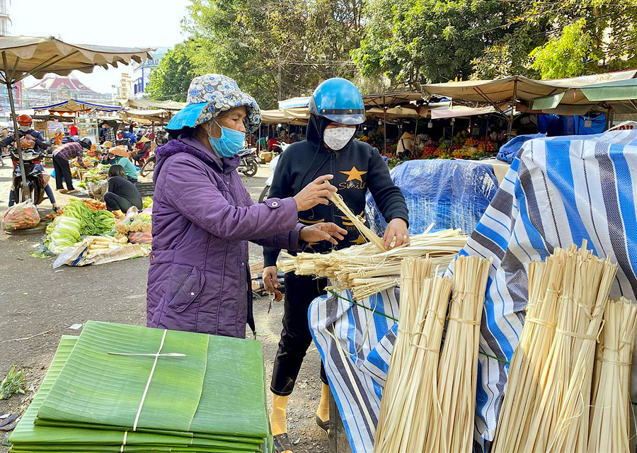 Như một thói quen, năm nào, bà Y Nun (bìa trái; phường Lê Lợi, TP. Kon Tum) cũng xuống TP. Pleiku để bán lá chuối và dây lạt. Ảnh: Mộc Trà