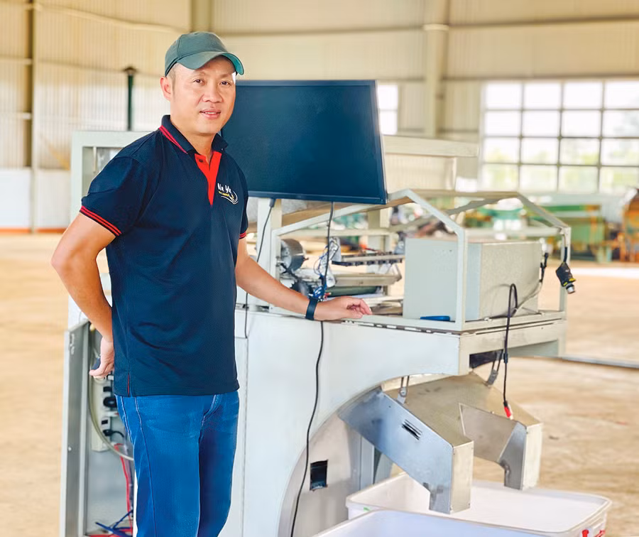  Anh Trương Việt Cường bên chiếc máy tách màu nông sản do mình sáng chế. Ảnh: Thảo Nguyên