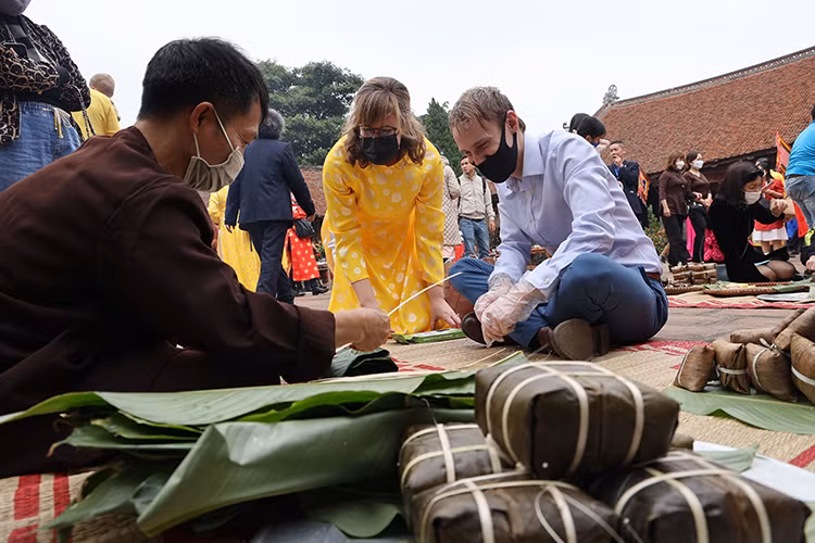 Nhân viên đại sứ quán các nước trải nghiệm các hoạt động trong Tết cổ truyền Việt Nam như gói bánh chưng, đổ kẹo lạc, nặn tò he...