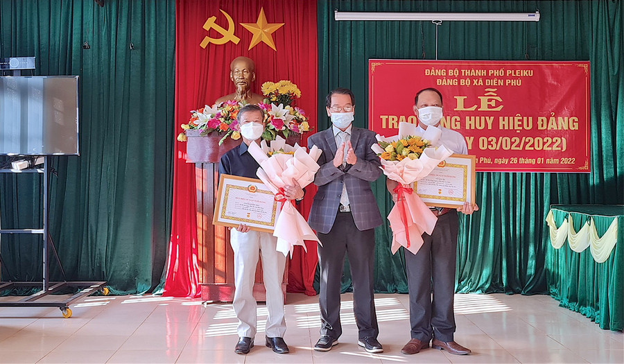  Phó Bí thư Thường trực Thành ủy Pleiku Trần Xuân Quang trao tặng Huy hiệu Đảng cho 2 đảng viên: Phạm Đình Thu (bìa trái) và Vũ Sơn Hà. Ảnh: Bá Bính